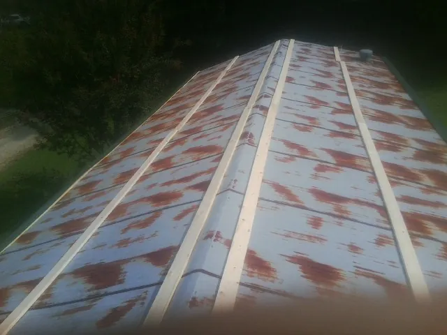 Rusted metal roof panels with new wood purlins before replacement — Storm Damage Roof Repair in Brogan by Roofing Brothers