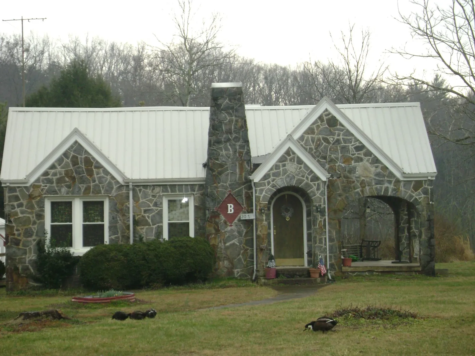 White metal roof on a stone cottage with steep gables in Brogan