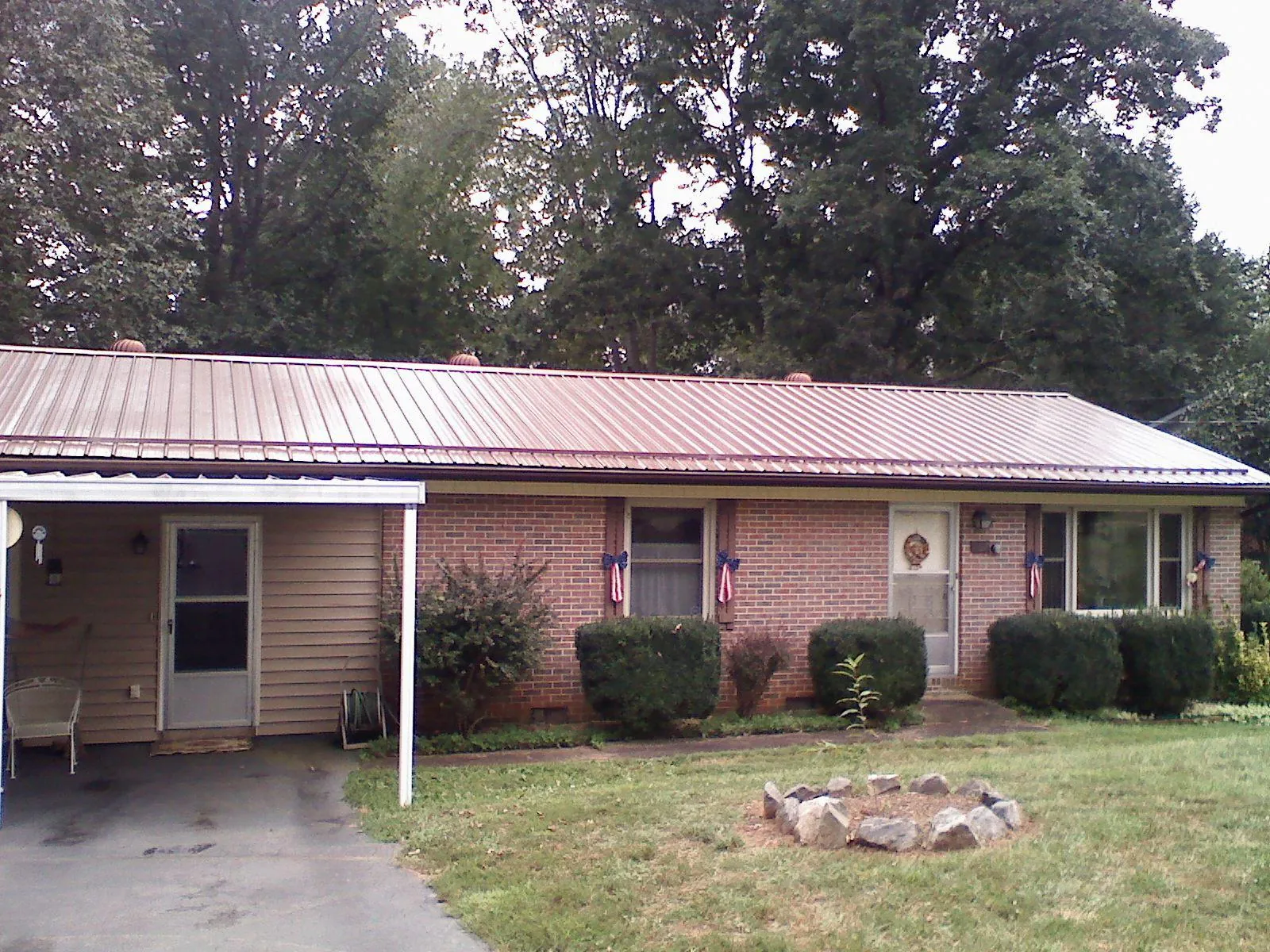 Bronze metal roof and carport on a brick ranch home — Roof Repair work by our crew in Brogan